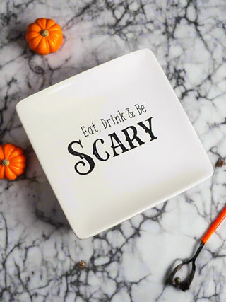 a small off white stoneware serving plate that reads eat drink and be scary in black type perfect for halloween decor
