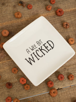 a small off white stoneware serving plate that reads a wee bit wicked in black type perfect for halloween decor