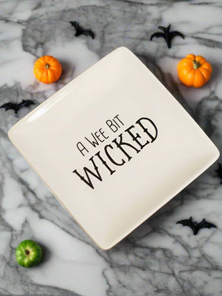 a small off white stoneware serving plate that reads a wee bit wicked in black type perfect for halloween decor