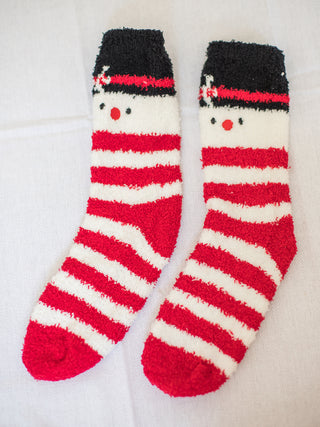 a pair of red and white fuzzy christmas socks in a snowman design perfect for holiday stocking stuffer gifts