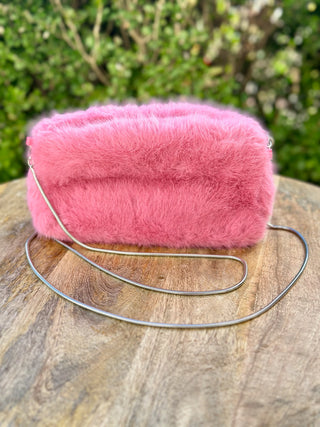 a chic fuzzy pink fur crossbody clutch bag with a silver strap
