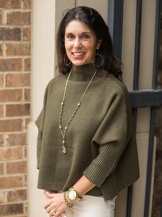 a loose crop turtleneck in a hunter green sweater material perfect as thanksgiving and christmas day outfits