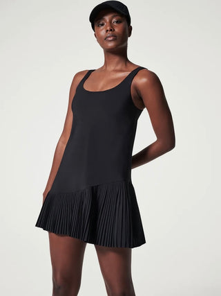a black sleeveless spanx dress featuring a pleated skort with active shorts underneath