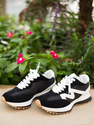 a pair of black and white lace up platform tennis shoes great for athleisure and daily wear