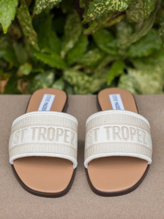 slip on slide sandal featuring a square open toe and single banded fabric upper that reads St Tropez 