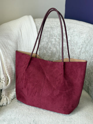 a large suede leather burgundy red tote bag