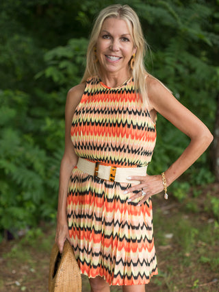 a multicolored print mini dress in shades of citrus with a sleeveless cut and cinched waist