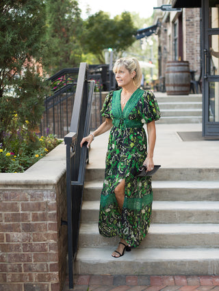 a green and black floral midi dress with puff sleeves and lace neckline perfect for fall fashion shown with black heels