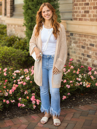 this taupe open weave knit cardigan has an open front with drop shoulder long sleeves and a knee length hem and pairs well with denim pants