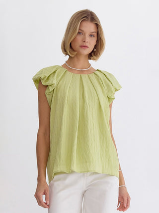 ruffled short sleeve honeydew color top with round neck and playful twist