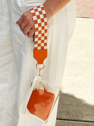 clear orange and white mini wristlet bag with checkered strap zipper closure and removable orange pouch inside