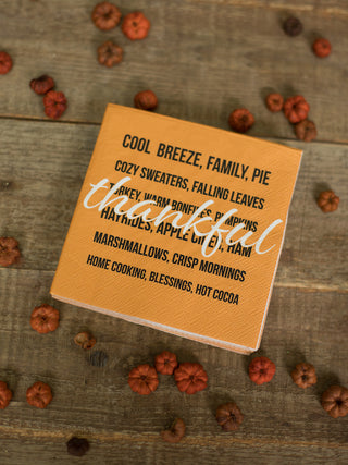 a pack of orange cocktail napkins with gratitude sentiments perfect for thanksgiving dinner and fall home decor