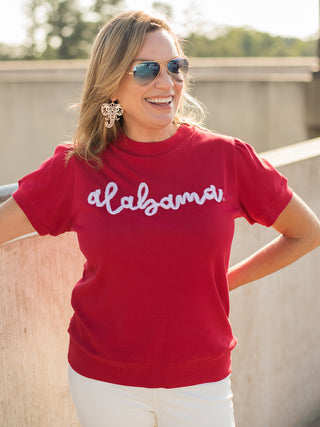 a red sweater tshirt with white glitter text that reads alabama perfect for bama fans and football fashion