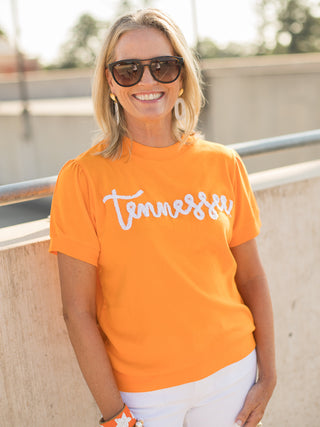 an orange sweater tshirt with white glitter text that reads tennessee perfect for vols football fans