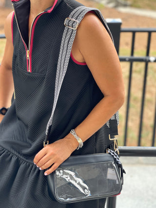 a clear cross body bag with black trim and attachable strap