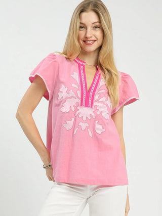 a spring pink abstract v neck top with a textured pattern