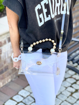 glamorous clear clutch bag with gold and pearl beaded handle and adjustable strap