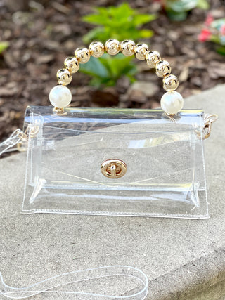 glamorous clear clutch bag with gold and pearl beaded handle and adjustable strap
