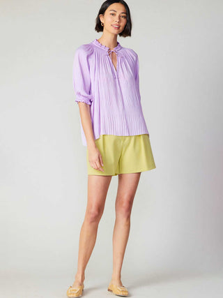 romantic lavender short sleeve pleated top with elastic cuffs worn with yellow shorts