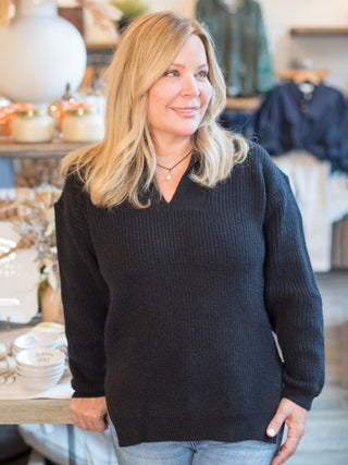 a v neck black sweater with long cuffed sleeves and a relaxed fit perfect for fall and winter fashion