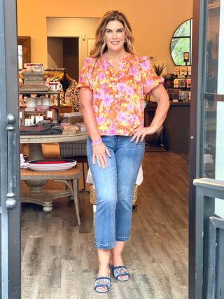 bright orange and pink floral blouse with silky tropical feel paired with blue jeans