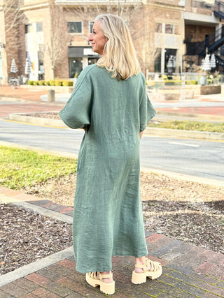 a chic and comfy light army green maxi dress with a low v neck worn with neutral sandals