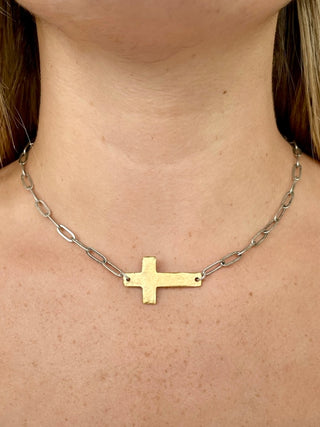 a gold chain necklace with a sideways cross 