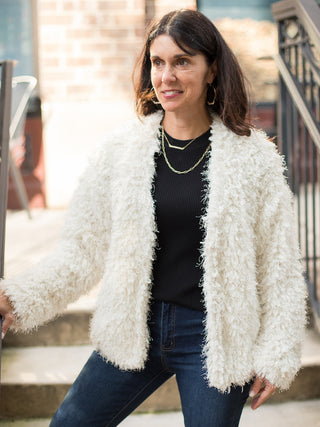 an ivory fuzzy jacket with long sleeves and an open front perfect for easy layering in fall and winter fashion