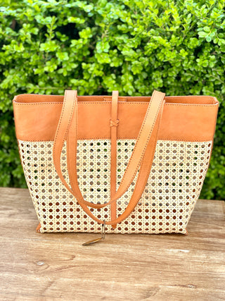 a stylish and trendy tote with cane weave pattern and tan grain leather trim