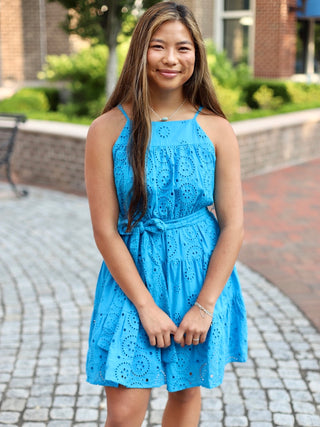 a turquoise eyelet lace mini dress with a cinched waist and key hole design at the back