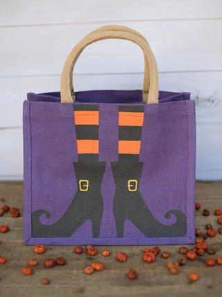a purple gift tote bag in jute fabric with witch stockings and boots perfect for halloween and fall