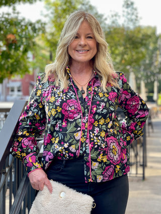 a jewel tone floral top with black accents and statement long sleeves perfect to bring a pop of color to cool weather fashion