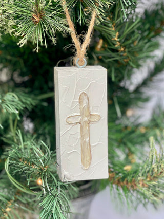 a painted white wooden plaque ornament with a cross image