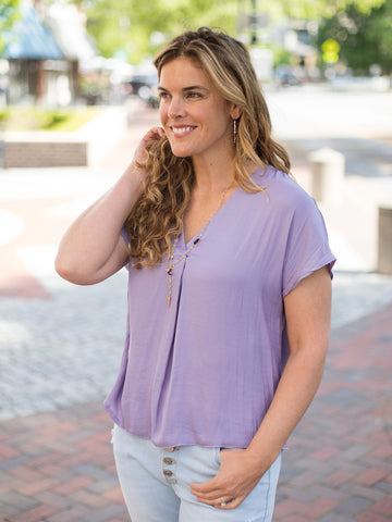 this lilac purple top has a front pleat beneath the v neckline and short sleeve drop shoulder