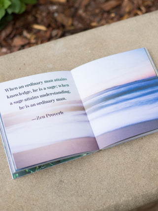 a spiritual quote inside the book set against a photo of the ocean shore