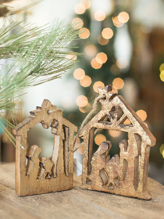 two wooden gold foil christmas tree ornaments in the shape of the nativity