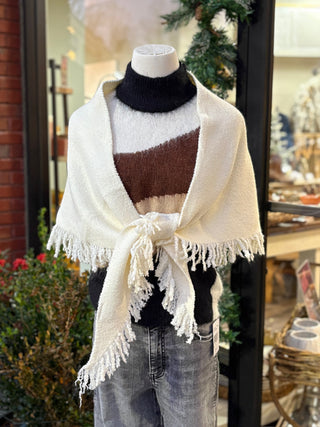 a wool ivory colored triangle wrap layered over a black striped turtleneck 