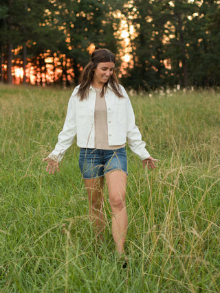 lightweight cropped bone white 100% cotton denim jacket with front pockets and dark shorts
