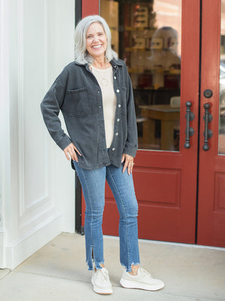 a black shacket with cream buttons and oversized sleeves perfect for layering in every season shown with denim pants