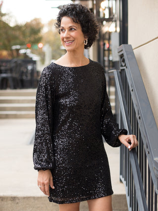 wear this black sequined mini dress with statement sleeves for a glamorous vibe at holiday parties and christmas events