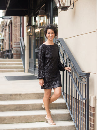 wear this black sequined mini dress with statement sleeves for a glamorous vibe at holiday parties with metallic gold heels