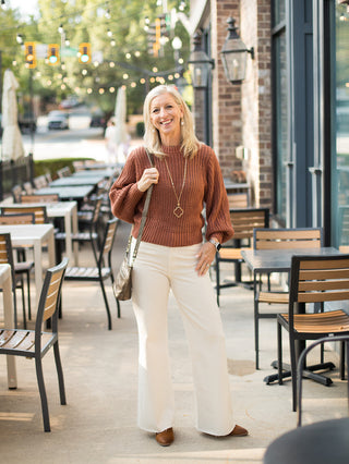 a penny brown knit sweater with long statement sleeves perfect for cozy fall fashion shown with ivory pants
