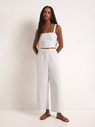 white relaxed fit wide gauze pants with elastic waste and drawcord worn with white crop top