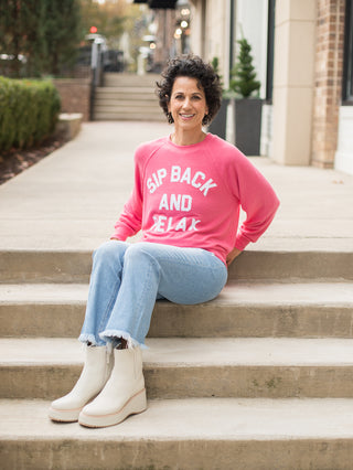 wear this bright coral sweatshirt with a witty wine saying as cozy loungewear and on holiday weekends with fringe jeans