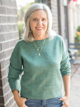 a chic sweater in green with long sleeves and a relaxed fit perfect for layering in every season
