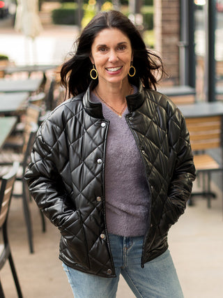 a black faux leather puffer jacket with quilted textures and a cool pop collar great for cold weather winter fashion