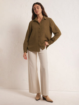 breathable brown long sleeve cotton gauze shirt with front button closure worn with beige pants