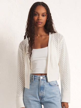 wear this white cropped cardigan with long sleeves and semi sheer crochet as an essential springtime layer
