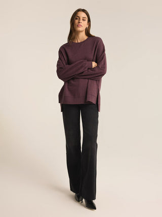 a cozy berry wine colored long sleeve pullover sweater worn with black pants