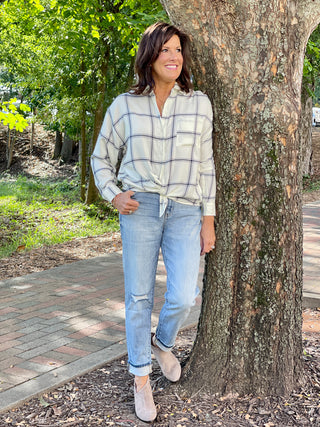 a long sleeve ivory button down blouse with navy blue plaid details perfect relaxed holiday fashion shown with denim pants